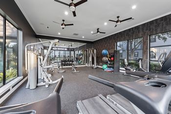 A gym with a variety of equipment including treadmills, weights, and exercise balls. at The Ambrose, Texas